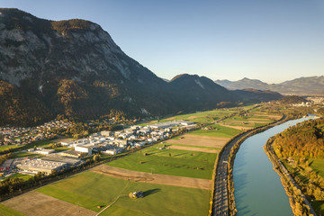 Aerial view of highway interstate road with fast moving traffic near big river in Alps mountains