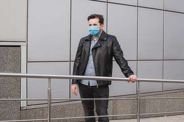 businessman on a background of closed office building, coronavirus, illness, infection, quarantine, medical mask