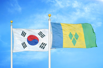 South Korea and Saint Vincent and the Grenadines two flags on flagpoles and blue cloudy sky