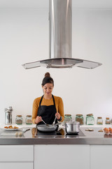 Young brunette woman frying homemade croquettes on a pan