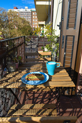 Desayunando en la terraza en un día soleado, tostada integral, aguacate, guacamole,  tomate, ,semillas de sésamo y café