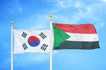 South Korea and Sudan two flags on flagpoles and blue cloudy sky