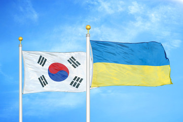 South Korea and Ukraine two flags on flagpoles and blue cloudy sky