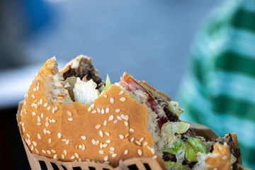A big, juicy piece of hamburger, bitten off. Close-up photos.