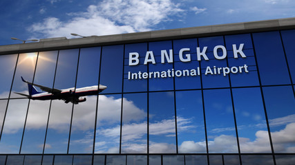 Airplane landing at Bangkok mirrored in terminal