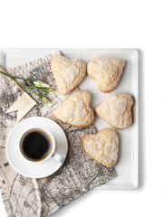 food photography of heart-shaped cookies with sugar topping with a cup of coffee on a white background isolated