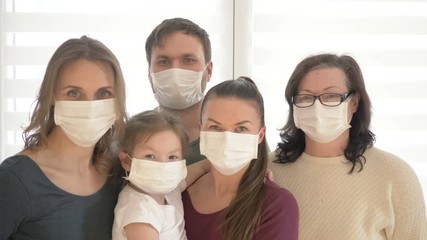 Family of five wears a protective medical mask to prevent coronavirus. Adults and children in medical masks to prevent disease