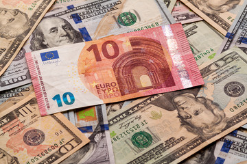 Fototapeta na wymiar Money and finances concept. Ten euro new bill on colorful abstract background of American national currency, dollar banknotes.