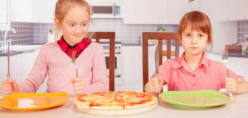 We love pizza!  Cute little girls best friends eating pizza. Horizontal image.