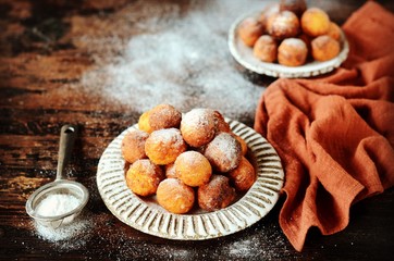 Cottage cheese donuts in a ceramic dish on a dark wooden table