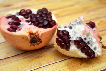 Beautiful composition with juicy pomegranates, on old wooden table