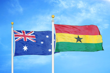 Australia and Ghana two flags on flagpoles and blue cloudy sky