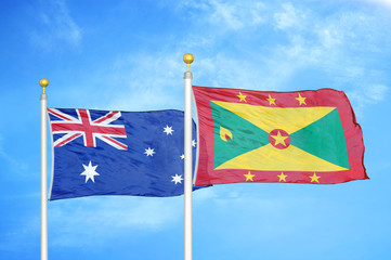 Australia and Grenada two flags on flagpoles and blue cloudy sky