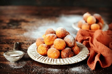 Cottage cheese donuts in a ceramic dish on a dark wooden table