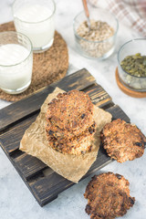 Oatmeal raisins on paper and a wooden stand with milk vertical arrangement