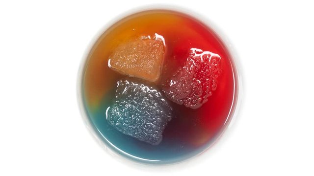 Ice of different colors melting in a bowl