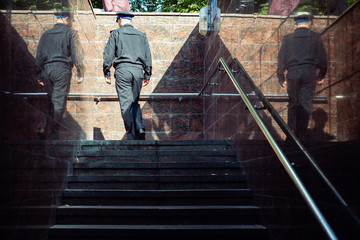 a man in uniform climbs the stairs from the underpass