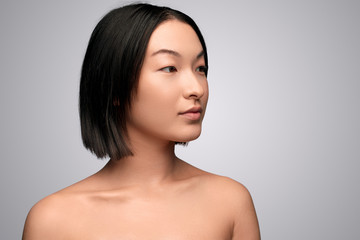 Asian woman with clean skin looking away