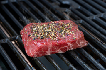 beef roast beef steak seasoned with coarse pepper and sea salt on the grill