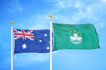 Australia and Macau two flags on flagpoles and blue cloudy sky