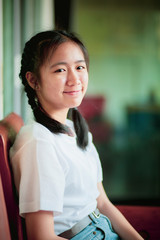 smiling face asian teenager sitting home living room