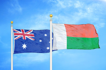 Australia and Madagascar two flags on flagpoles and blue cloudy sky