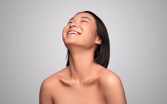 Laughing Asian woman with perfect skin