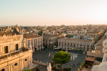 Fototapeta na wymiar Catania, Sicily in Italy. Aerial view of the city roofs and in particoular the magnificent Duomo square at sunset, nice warm colors and soft light. Shot from the badia of Sant'Agata church