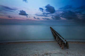 Wooden breakwater in the sea at sunrise in Hindeloopen in Holland.