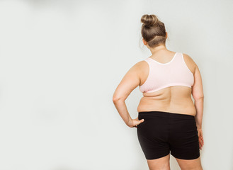 Obraz premium Woman with fat abdomen, overweight female stomach, stretch marks on belly closeup, white background
