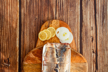 sliced salted herring on plate onion rings  lemon