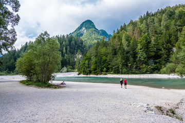 Triglav, Slovenia - August 11, 2019: Hikers have a rest on the river bank in Triglav national park. Julian Alps, Triglav, Slovenia