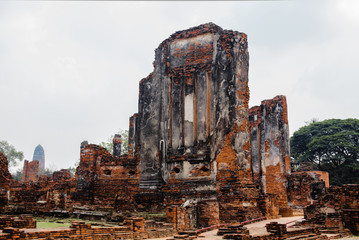 Ruined temple on a lawn. Red brick ancient asian building