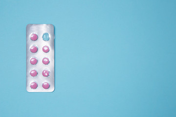 Blister of pills isolated on blue surface stock photo