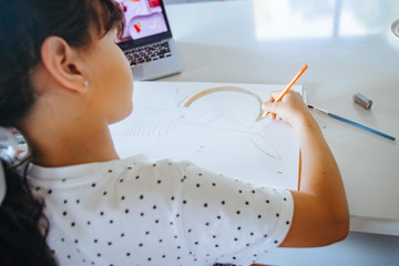 young caucasian girl drawing at home, on-line art calss, home schooling, stay home education