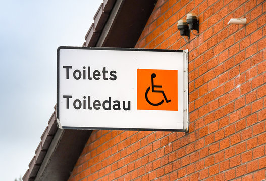 Bilingual sign for toilets on the outside of a building, 