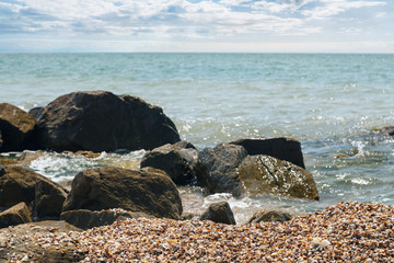 Fototapeta na wymiar Sea coast and sky, wet stones, waves. Background