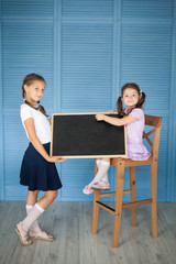 School girls in a uniform with a chalkboard. Back to school