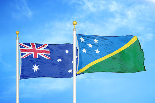 Australia and Solomon Islands two flags on flagpoles and blue cloudy sky