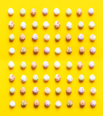 Square seamless pattern from multicolored speckled chocolate eggs on bright yellow background. Easter card poster banner template. Minimalist creative trendy style