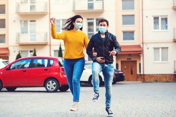 Young couple in protective medical mask on face outdoors. Coronavirus spread prevention. Spring lifestyle 2020.