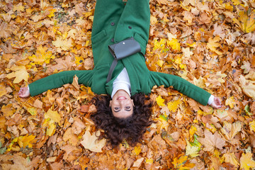 Happy lady relaxing on the ground on autumn day stock photo