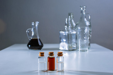 A large decanter and a test tube with a dark liquid stand next to the decanter and test tubes with a light liquid