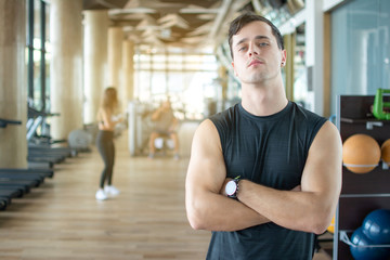 Fototapeta na wymiar Personal trainer with is arms crossed in a gym