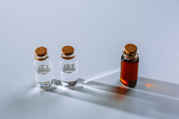 a test tube with a dark liquid stands next to the test tubes with a light liquid