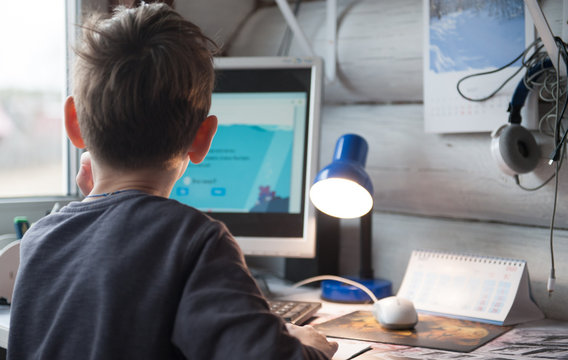 schoolboy doing homework at home at the computer on the online platform. Home schooling, quarantine.