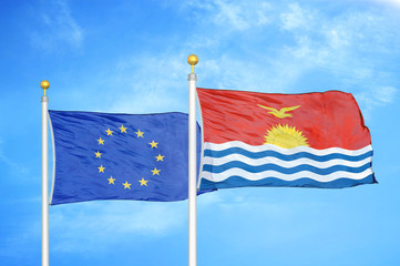 European Union and Kiribati two flags on flagpoles and blue cloudy sky