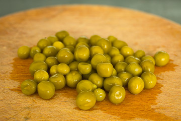 Varios guisantes sobre una tabla de madera