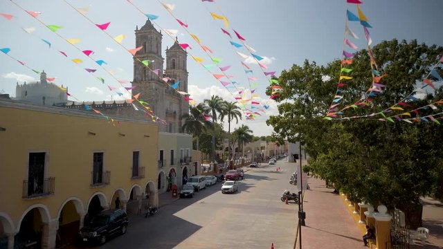 The cathedral San Gervasio and the Zocalo, or central park with flag waving in Valladolid, Yucatan, Mexico.