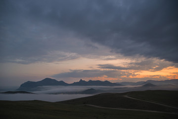 Fototapeta na wymiar Mountains in the evening fog and the village under the fog